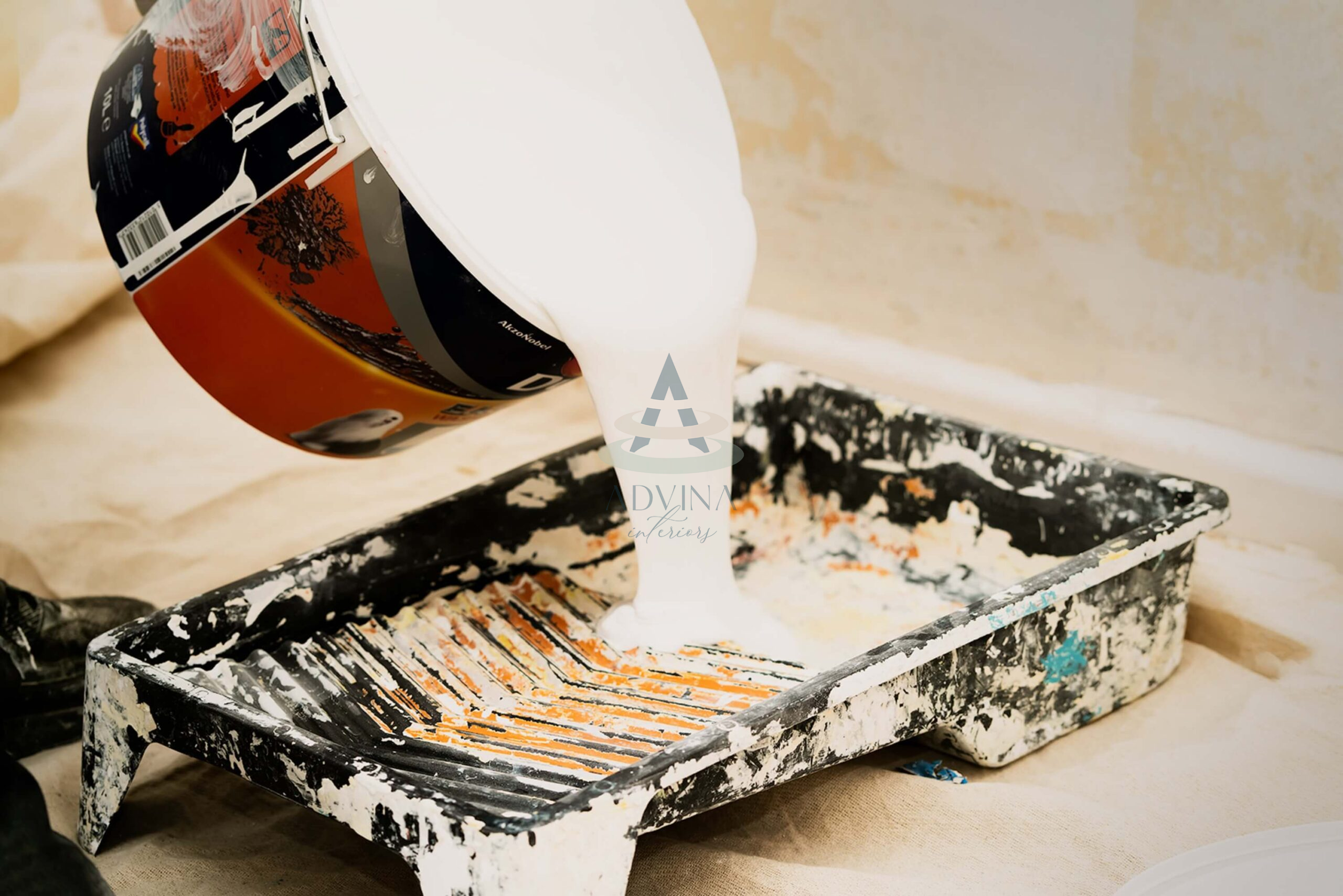 White paint flowing from a bucket during an interior renovation service.